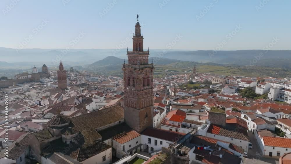 An atmospheric circling panoramic of Iglesia de San Bartolomé. Jerez de Los Caballeros, Badajoz, Extremadura, Spain with hills and mountains on the misty horizon