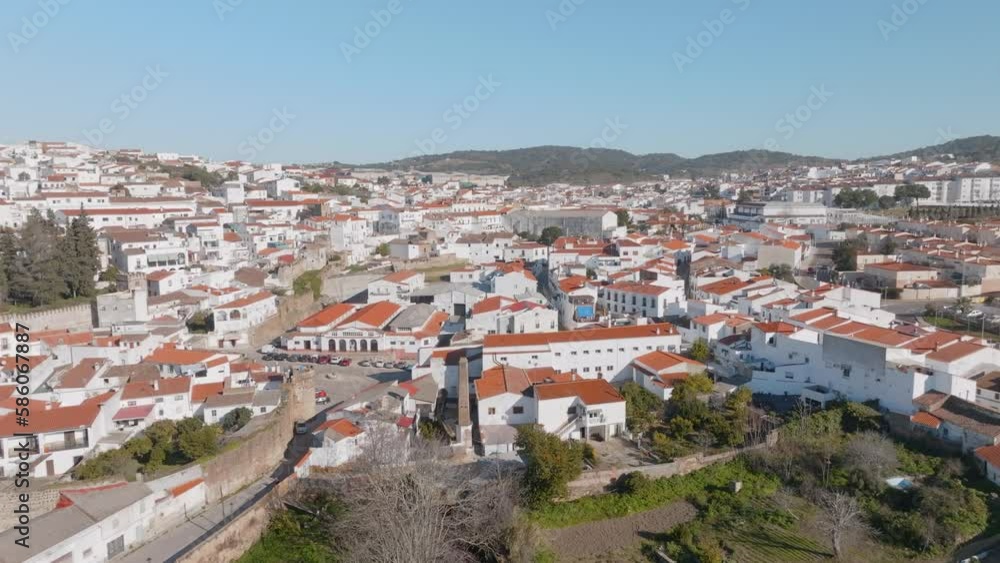 Aerial establishing shot of a traditional spanish town with white buildings and red roofs in Jerez de Los Caballeros, Badajoz, Extremadura, Spain with hills on the hirozon Aerial establishing shot of a traditional spanish town with white buildings and red roofs in Jerez de Los Caballeros, Badajoz, Extremadura, Spain with hills on the hirozon
