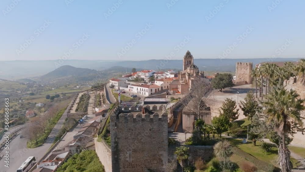Aerial shot of Alcazaba de Jerez de Los Caballeros, a beautiful castle fort and historic landmark in a traditional spanish town in Badajoz, Spain. Rolling hills on the horizon a palm trees in the sun. Aerial shot of Alcazaba de Jerez de Los Caballeros, a beautiful castle fort and historic landmark in a traditional spanish town in Badajoz, Spain. Rolling hills on the horizon a palm trees in the sun.