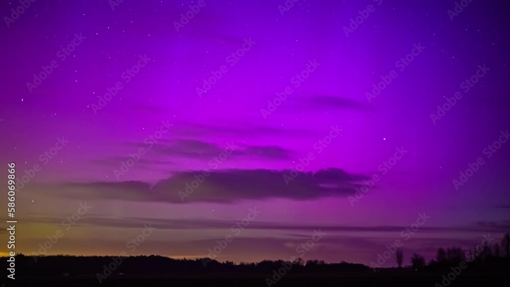 Timelapse shot of silhouette trees under colorful polar lights aurora borealis in dark at night time. Timelapse shot of silhouette trees under colorful polar lights aurora borealis in dark at night time.