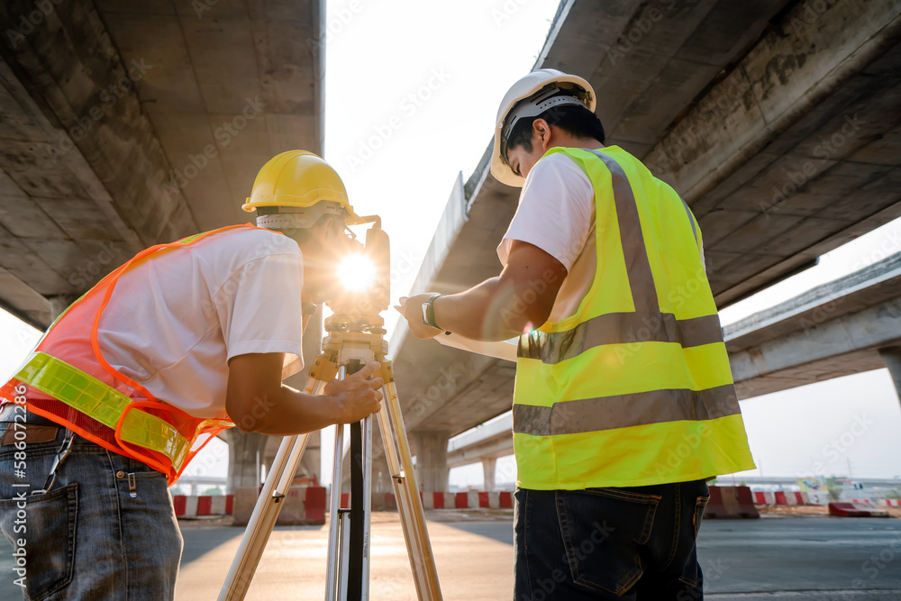 Asian civil engineer team working with theodolite and highway