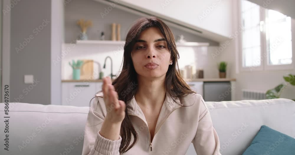 A female coach talks, conducts a webinar online, tells useful things on camera and teaches a large number of people, smiling, gesticulating. A female coach is sitting on the sofa in the living room. A female coach talks, conducts a webinar online, tells useful things on camera and teaches a large number of people, smiling, gesticulating. A female coach is sitting on the sofa in the living room.