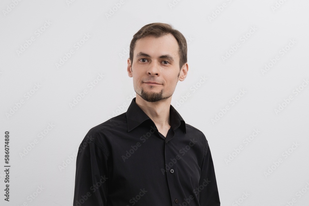 Just a portrait of caucasian man in his 30s with a beard and in a black shirt on a white background. Just a portrait of caucasian man in his 30s with a beard and in a black shirt on a white background.