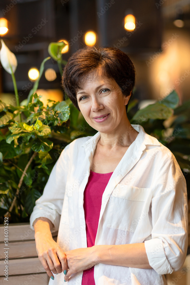 portrait of cute middle aged jewish woman in cozy green house. plant care. happy female smiling, care for flowers. beautiful stylish adult jew home gardening portrait of cute middle aged jewish woman in cozy green house. plant care. happy female smiling, care for flowers. beautiful stylish adult jew home gardening