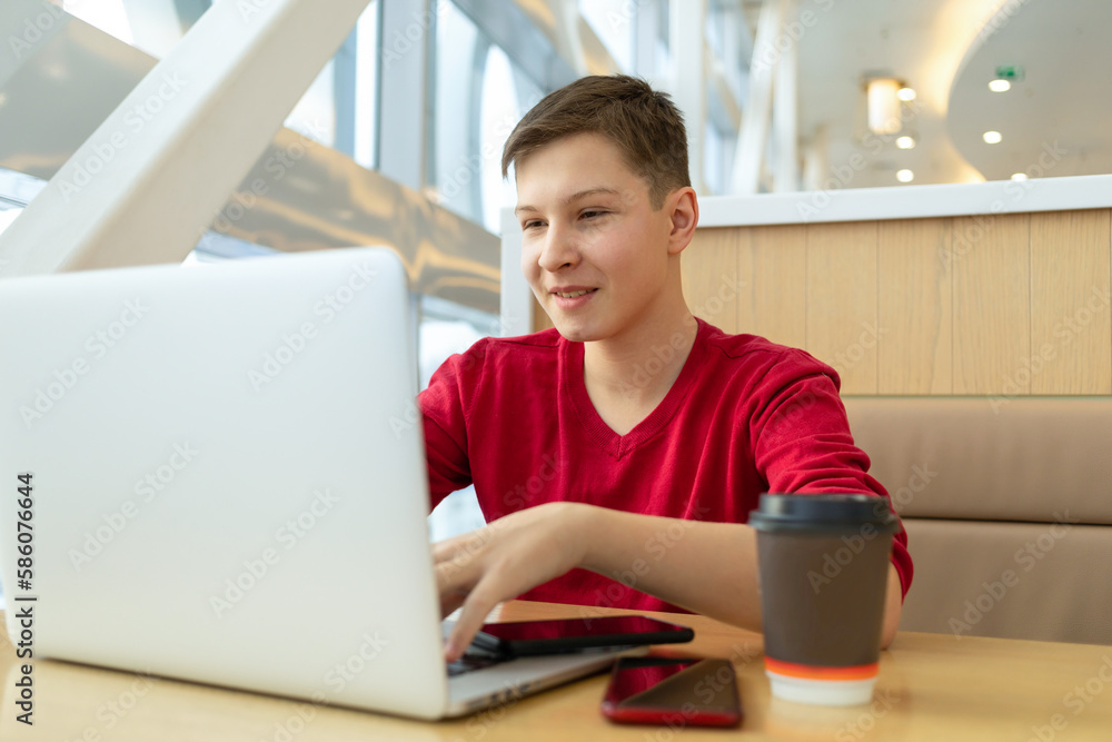 teenager at computer doing homework at computer, getting new knowledge, remote work for students on Internet. Teen boy working chat with internet friends. Student studying on the web teenager at computer doing homework at computer, getting new knowledge, remote work for students on Internet. Teen boy working chat with internet friends. Student studying on the web