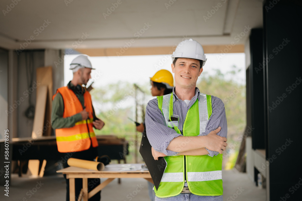 Contractor and architect looking at plan, tablet, laptop and talking about working on big project. Building in construction process interior. team work . Contractor and architect looking at plan, tablet, laptop and talking about working on big project. Building in construction process interior. team work .
