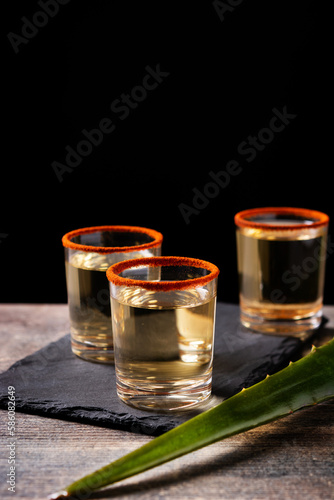 Mezcal Mexican drink with worm salt on wooden table. Copy space
