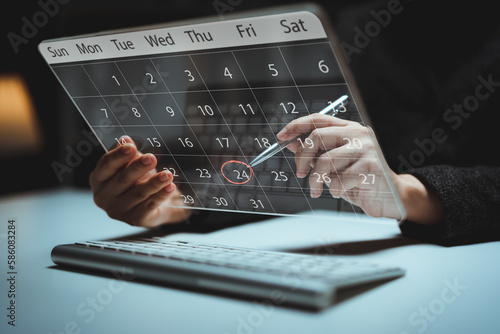 Businessperson or secretary manages time for effective work. Calendar on the virtual screen interface. Highlight appointment reminders and meeting agenda on the calendar. Time management concept.