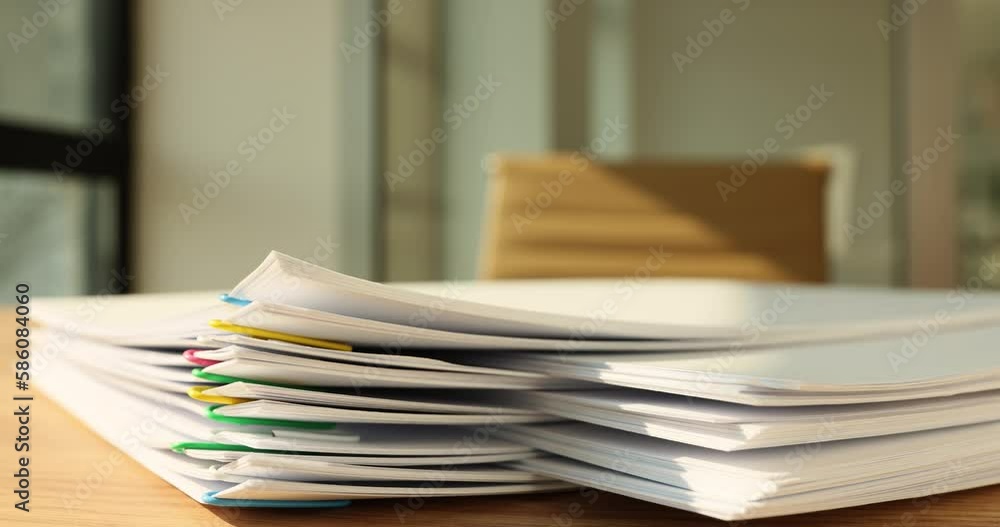 Taking papers connected with paperclips from pile on table