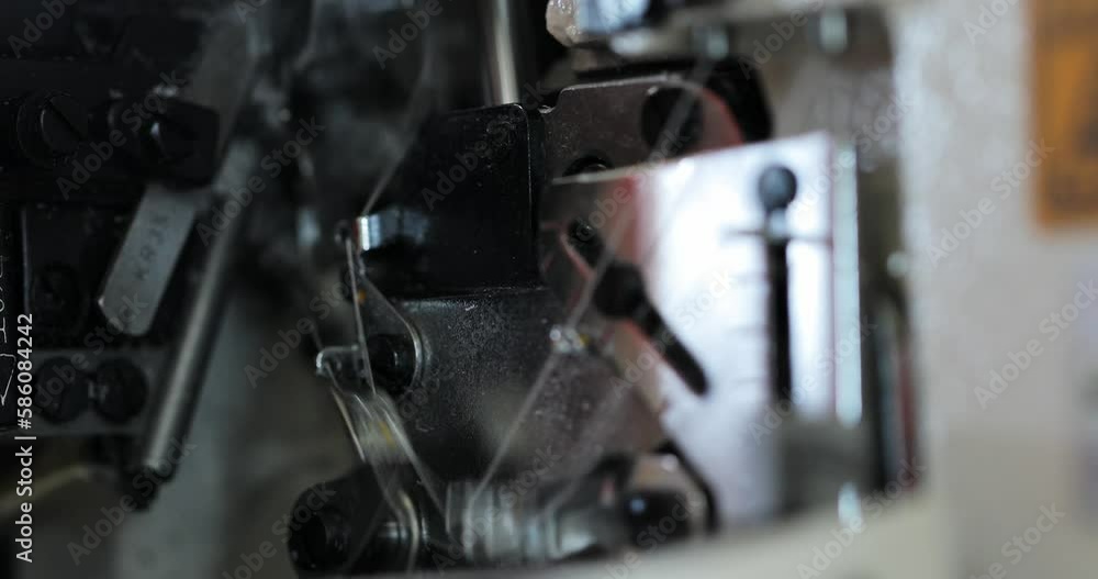 working mechanisms of an overlock sewing machine. macro. in the automatic sewing machine, the