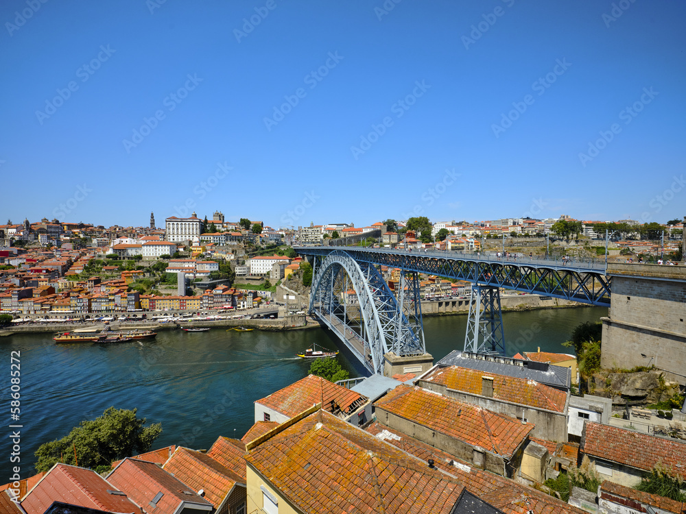 Panoramic view of the historic city of Porto, crossed by the Douro River, in Portugal. View of the Dom Luis 1 iron bridge, on a sunny day.