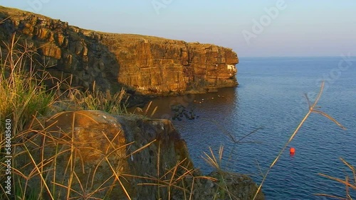 Seascape - rocky cape of Snake Island against the background of the sea, sunset lighting. Black Sea, Ukraine. photo