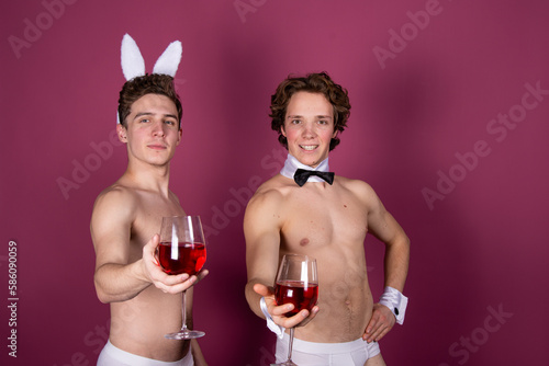 Easter. Two young attractive guys dressed as rabbits. © vladorlov