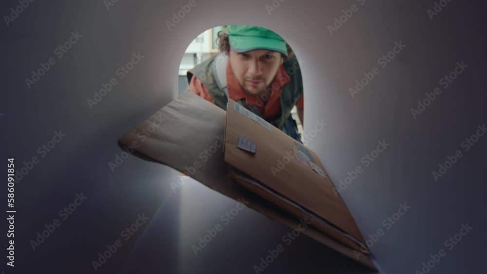 Postman opening mailbox, putting several envelopes inside, and then closing while delivering letters. POV shot from inside of the mailbox