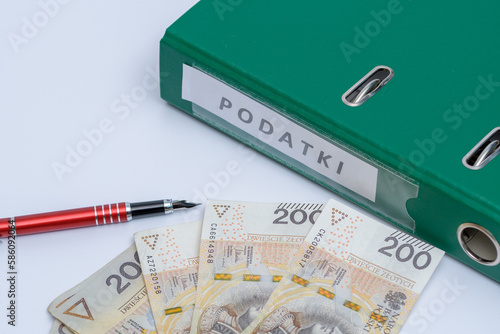 Segregator z dokumentami podatkowymi obok polskich banknotów 