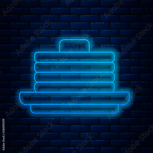 Glowing neon line Stack of pancakes icon isolated on brick wall background. Baking with syrup and cherry. Breakfast concept. Vector