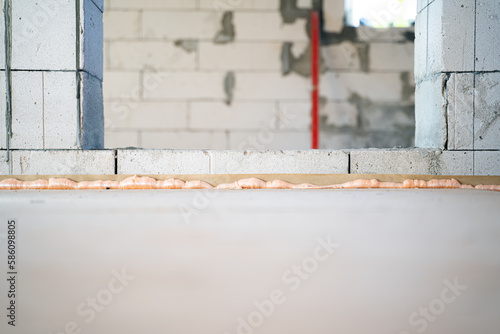 Doorway in the wall of the gas block. High threshold between rooms. Floor height difference in a private house. Subfloor made of Oriented Strand Board. Slot filled with construction foam