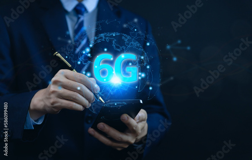 businessman holding a smartphone with hologram 6G digital technology. 6G wireless internet network concept or IOT  high speed communication connection. 