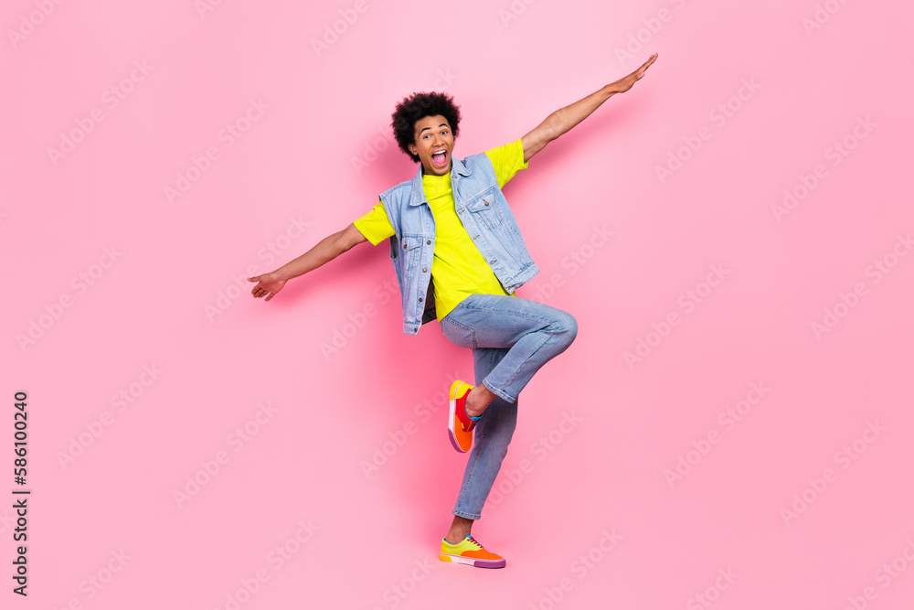 Full length photo of cheerful overjoyed man wear stylish clothes dream fly abroad empty space isolated on pink color background