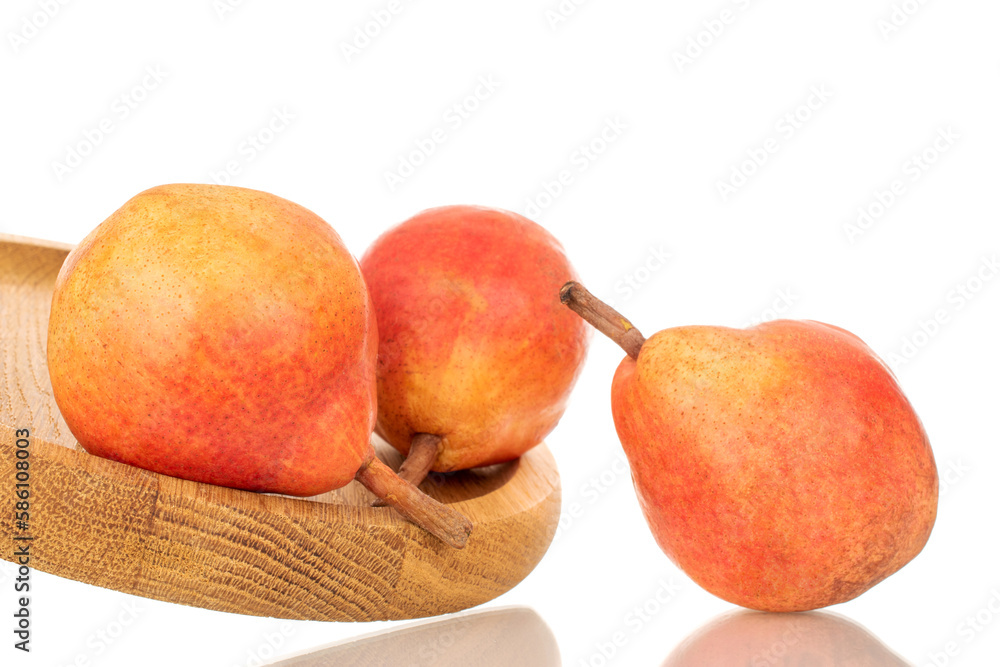 Three organic Bartlett pears on a wooden tray, macro, isolated on white background. Three organic Bartlett pears on a wooden tray, macro, isolated on white background.