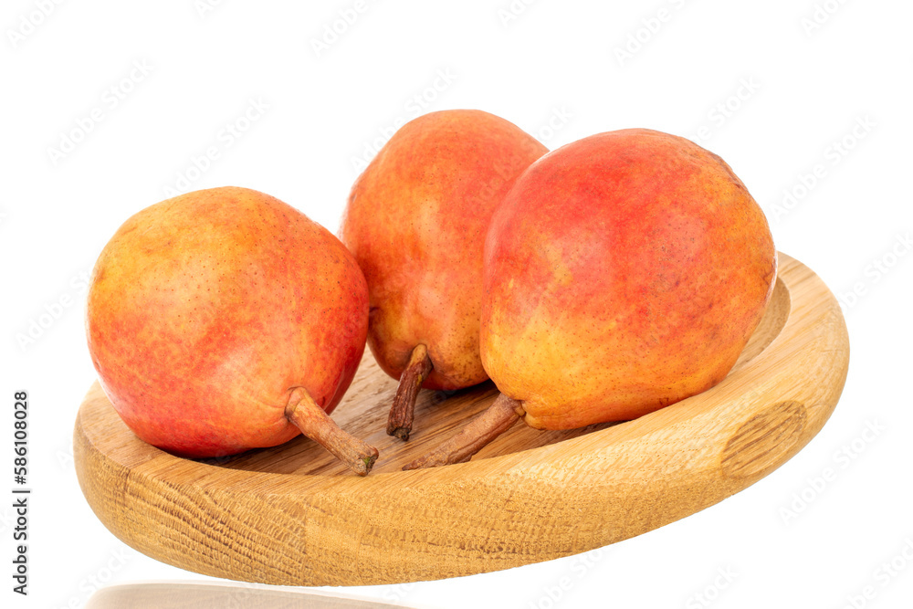 Three organic Bartlett pears on a wooden tray, macro, isolated on white background. Three organic Bartlett pears on a wooden tray, macro, isolated on white background.