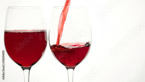 Pouring red wine into glass from the bottle on the white background
