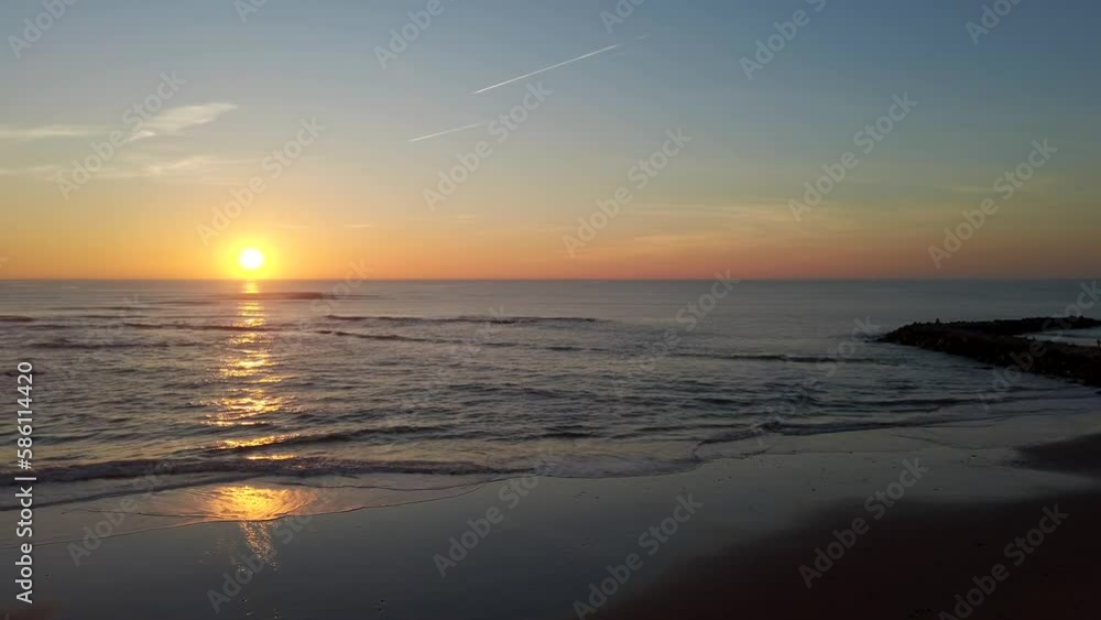 Incredible sunrise over ocean waters pan to views of tourists on beach in Cadiz Incredible sunrise over ocean waters pan to views of tourists on beach in Cadiz