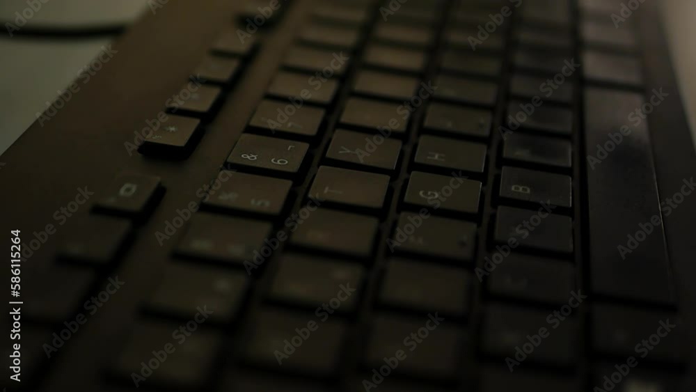 Close up shot of black keyboard and computer inside office - panning shot Close up shot of black keyboard and computer inside office - panning shot