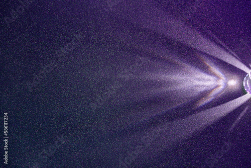 On a dark purple structural fine-grained background, a light purple scattered beam of light