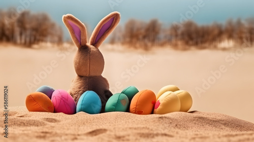 Rabbit toy and easter eggs at the beach. Shallow depth of field. Concept of happy easter day.