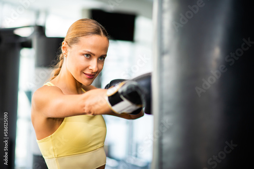 Woman training on the punching bag in a gym © Minerva Studio