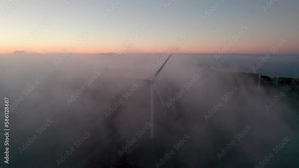Wind Turbine spinning amongst low clouds at sunrise, Madiera, Portugal Wind Turbine spinning amongst low clouds at sunrise, Madiera, Portugal