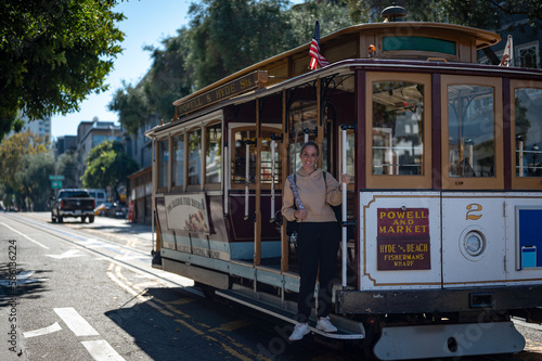 Portrait of a young blonde tourist girl boarding the San Francisco Cable Car