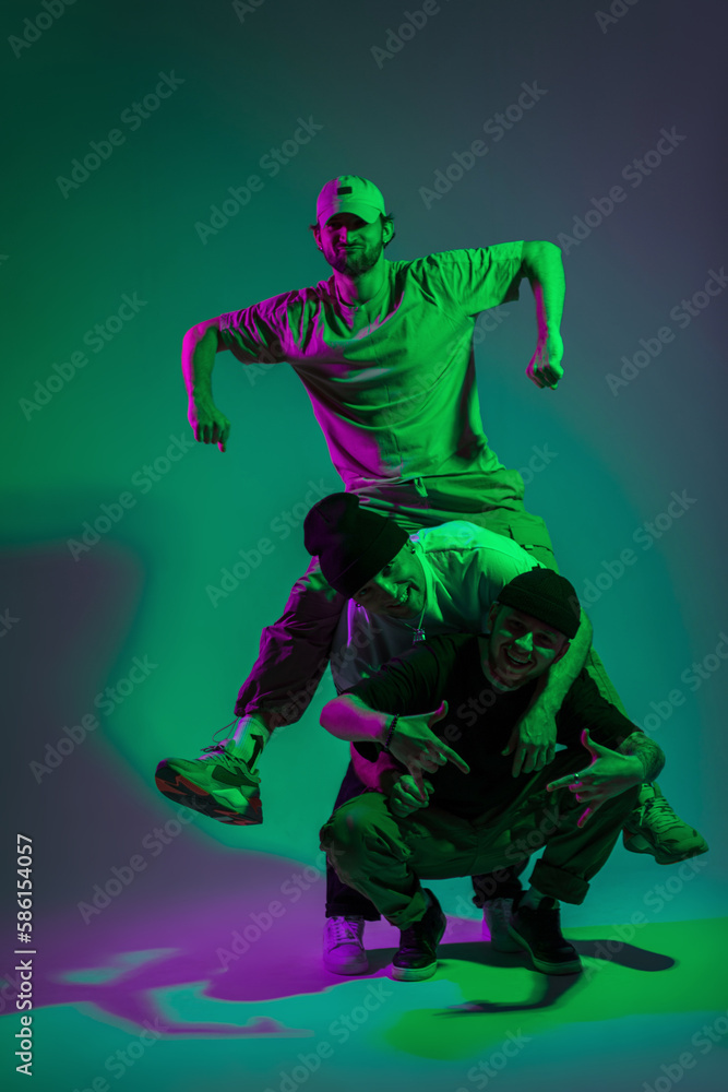 Cool happy funny team of dancers in fashion clothes posing in a creative studio with cyan and magenta color Cool happy funny team of dancers in fashion clothes posing in a creative studio with cyan and magenta color