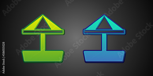 Green and blue Sandbox for kids with sand and umbrella icon isolated on black background. Vector