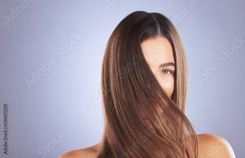 Woman, beauty and hair portrait in studio for space, growth and healthy shine on blue background. Aesthetic female model for haircare texture, self care and cosmetic results for salon or hairdresser photo