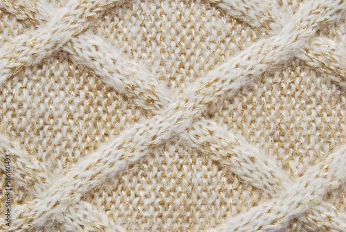 Foto Beige soft woolen sweater surface with crossed cable ornament texture and golden