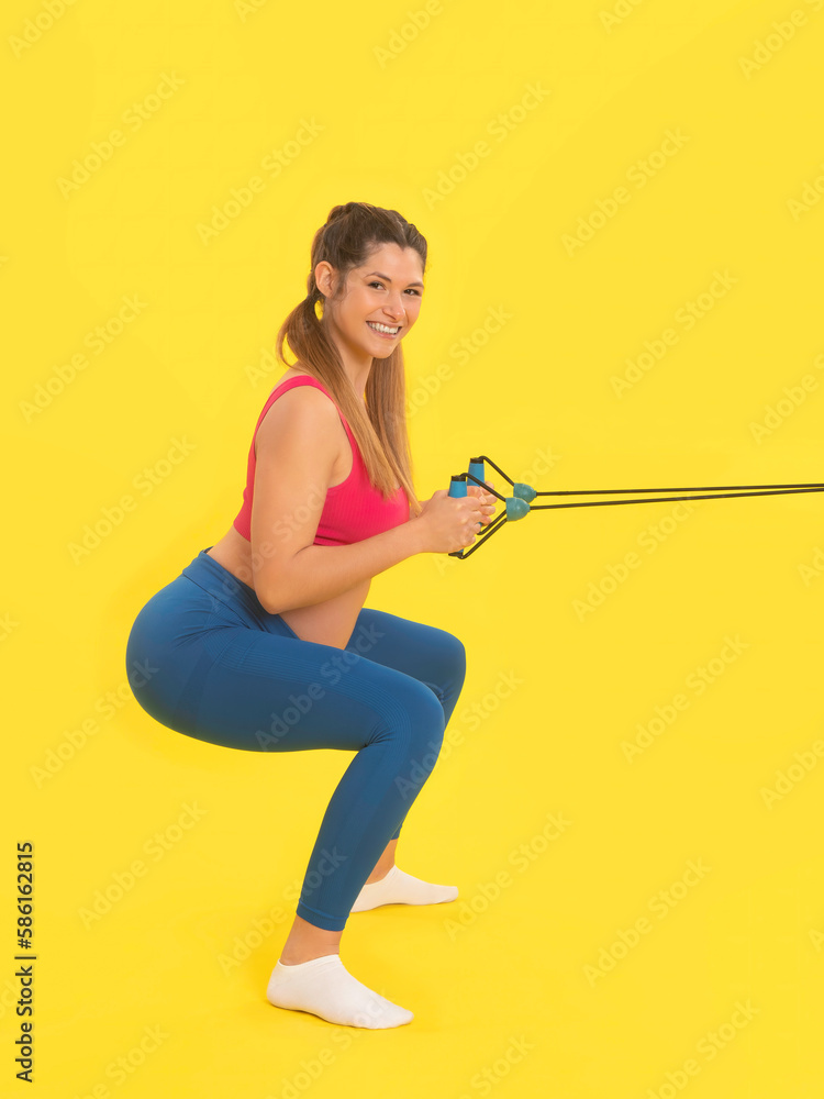 Young pregnant woman exercising in squash knee pose with elastic band Young pregnant woman exercising in squash knee pose with elastic band