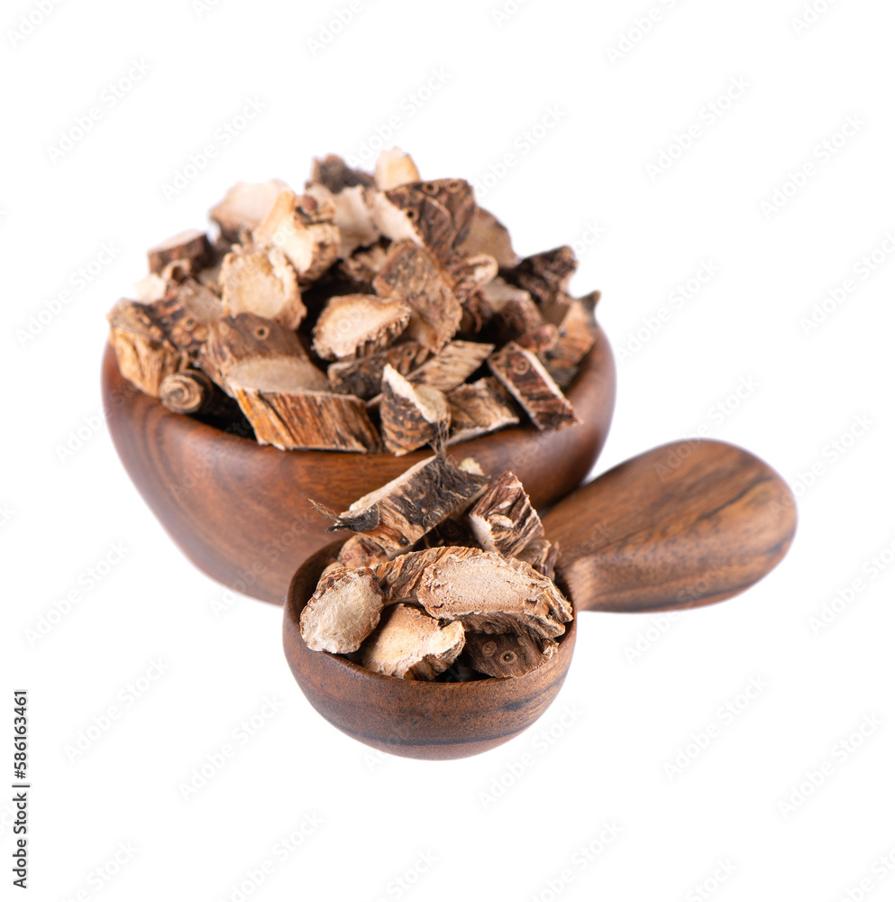 Obraz premium Calamus root in wooden bowl and spoon, isolated on white background. Sweet flag, sway or muskrat root. Dry root of Acorus calamus.