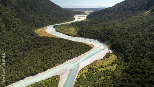 Confluence of two glacial rivers and wild nature scenery of Westland, New Zealand - aerial pull back landscape photo