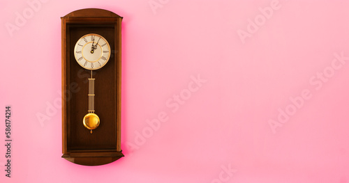 Oldschool clock on a pink wall. Copy space for additional content. © To Studio