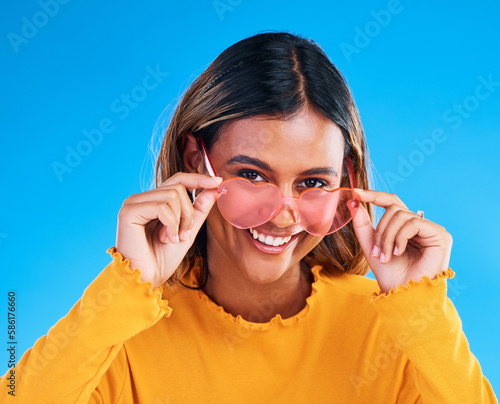 Fashion portrait  heart glasses and happy woman with young style  designer brand or casual summer outfit. Trendy gen z aesthetic  girl smile and female model face on blue background studio