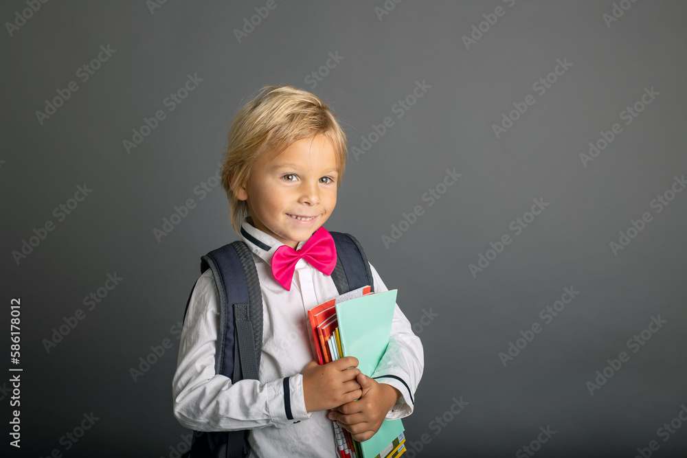 Cute preschool blond child, boy, holding books and notebook, apple, wearing glasses, ready for school Cute preschool blond child, boy, holding books and notebook, apple, wearing glasses, ready for school