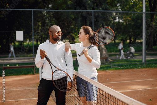 Black man talking with woman at tennis court © prostooleh