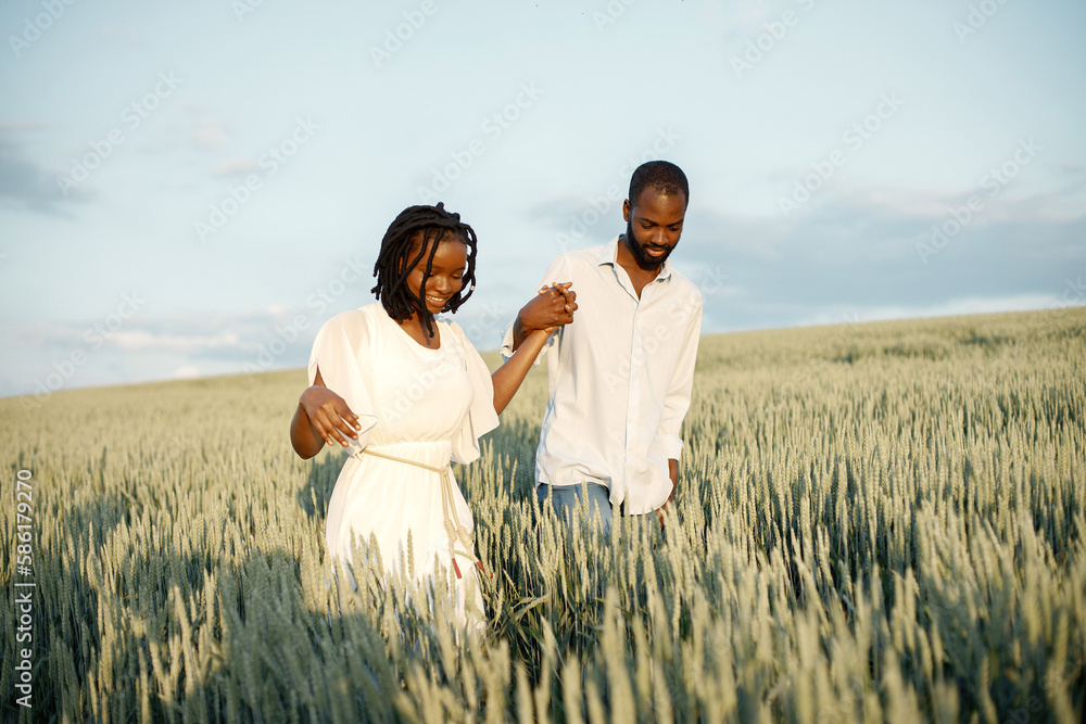 Young black couple walking through green field Young black couple walking through green field