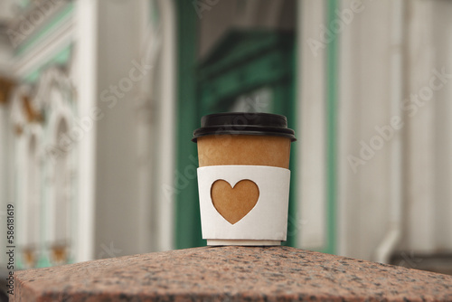 paper cup of natural coffee with carved white heart on on Palace Square in St. Petersburg photo