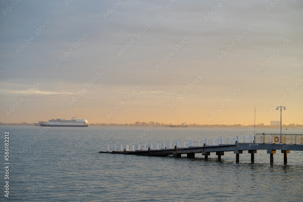 Modern concrete dock with cruise ship background during sunrise