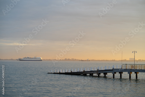 Modern concrete dock with cruise ship background during sunrise