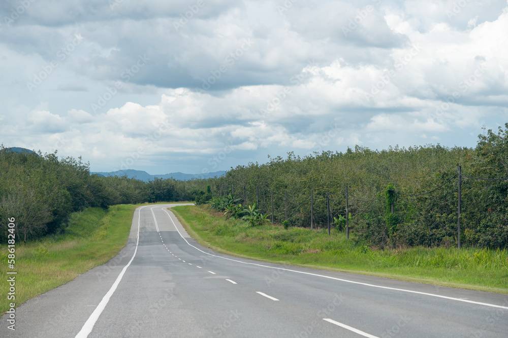 Country highway running curve toward the end of the road in cloudy day Country highway running curve toward the end of the road in cloudy day