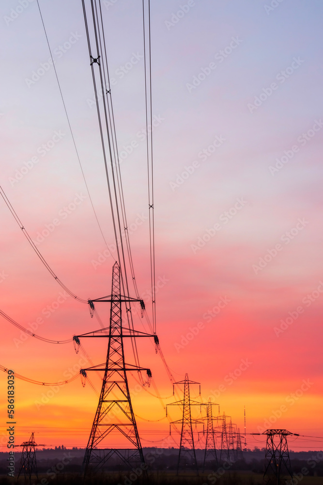 Portrait view of evening sky with power pylons silhouetted